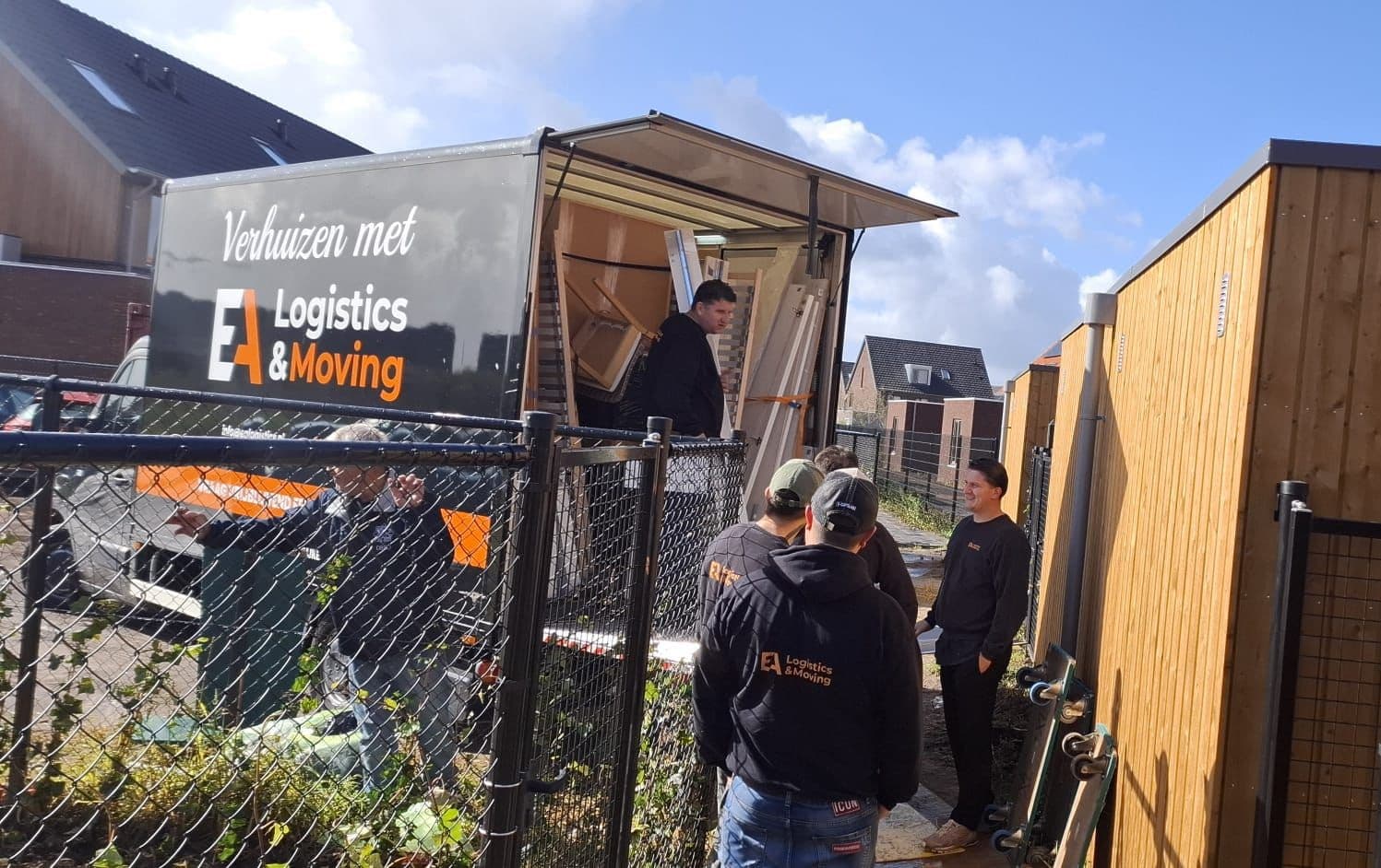 Medewerkers van EA Logistics & Moving lossen verhuisbus uit