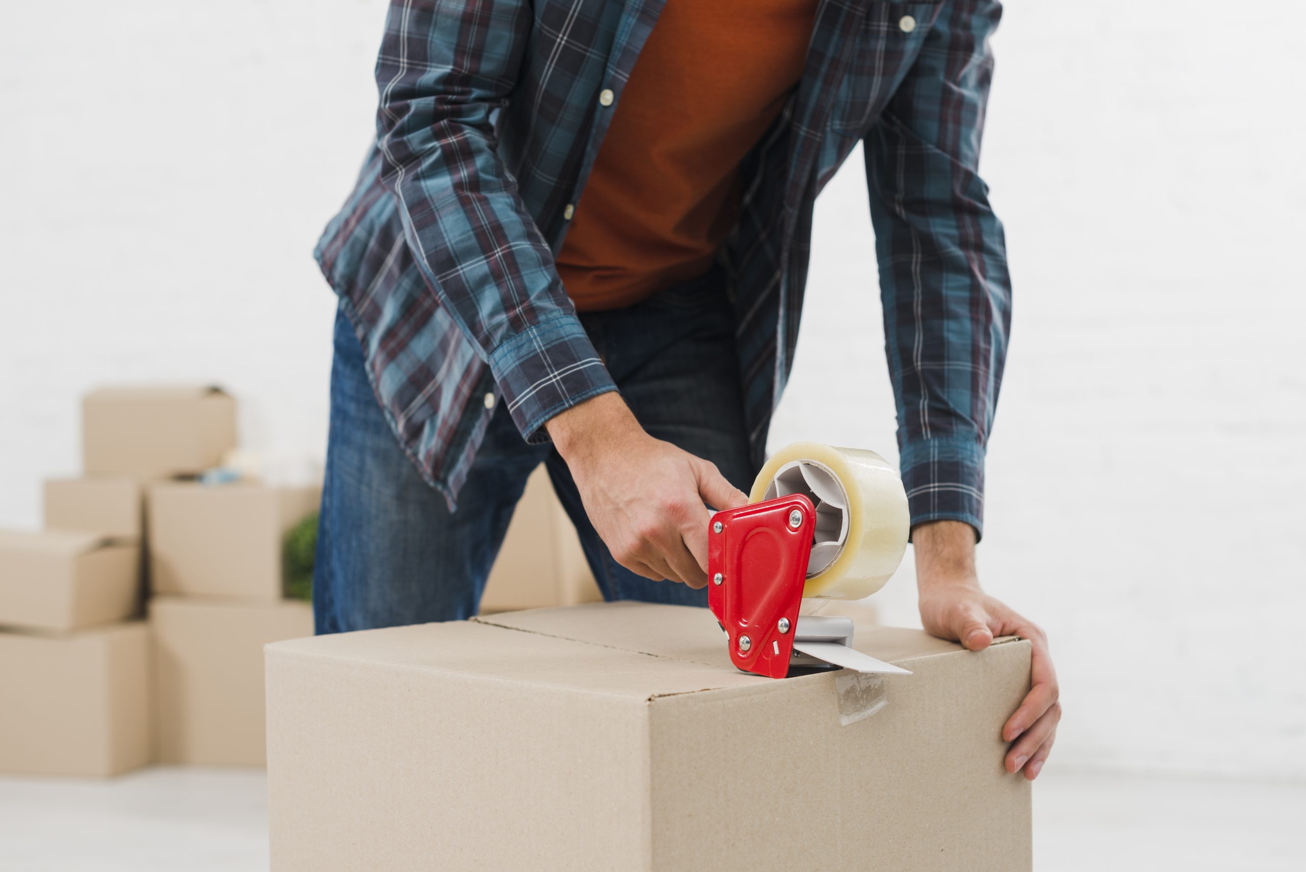 close-up-man-sealing-cardboard-box-with-duct-tape